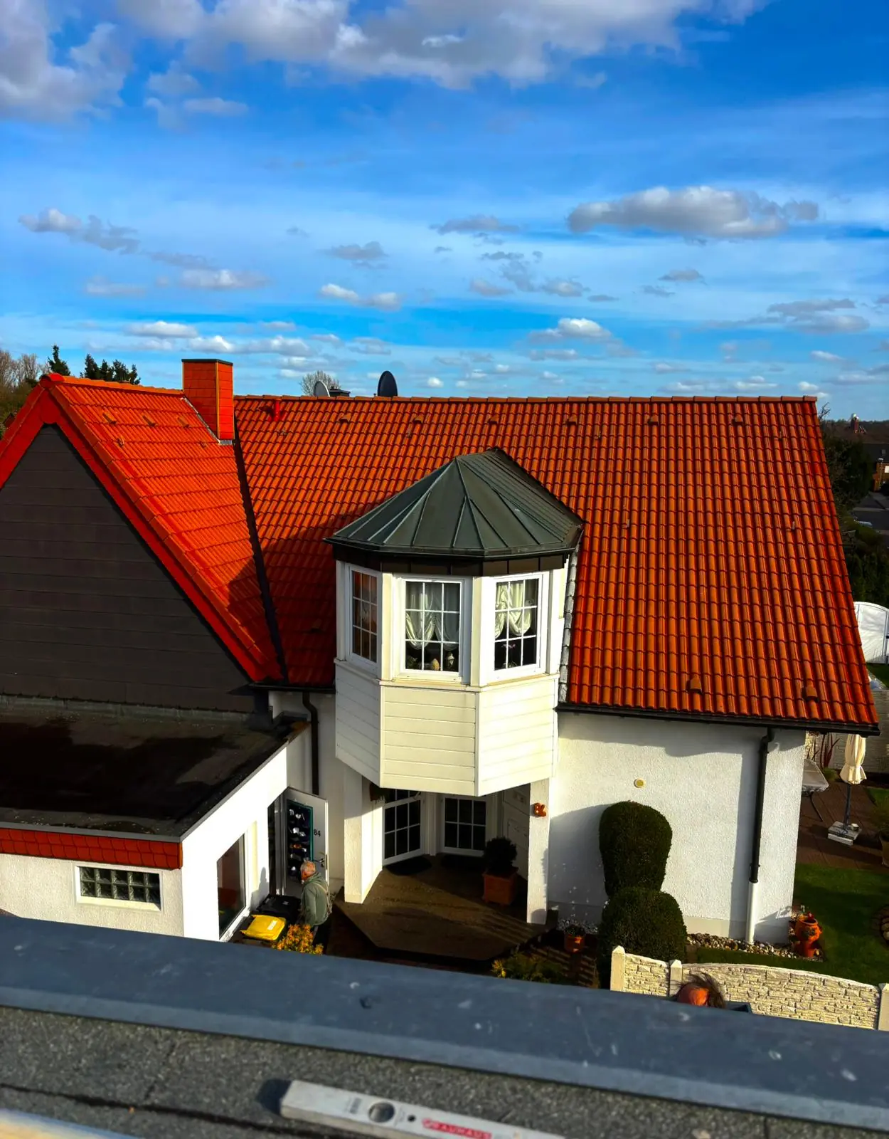 Nachher-Ansicht einer Dachbeschichtung in NRW: Das sanierte Ziegeldach mit Gauben erstrahlt in neuem Glanz nach der professionellen Sanierung durch Brand Sanierungen.