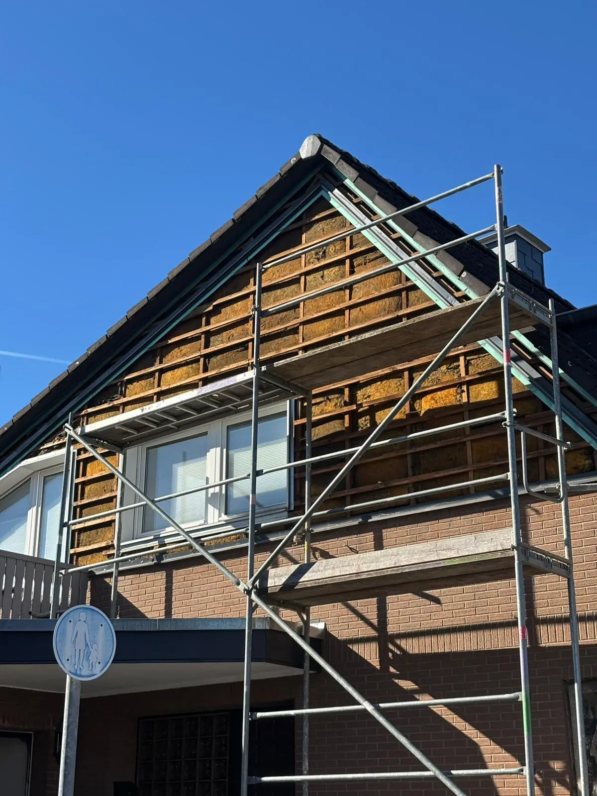 Außenanlage in NRW Vorher: Ein in die Jahre gekommener Holzzaun und unebene Gehwege vor der Modernisierung des Gartenbereichs.